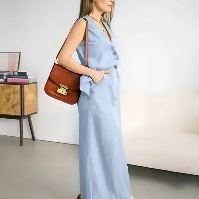 A woman wearing a blue sleeveless vest and matching long skirt from a polyester two-piece suit.