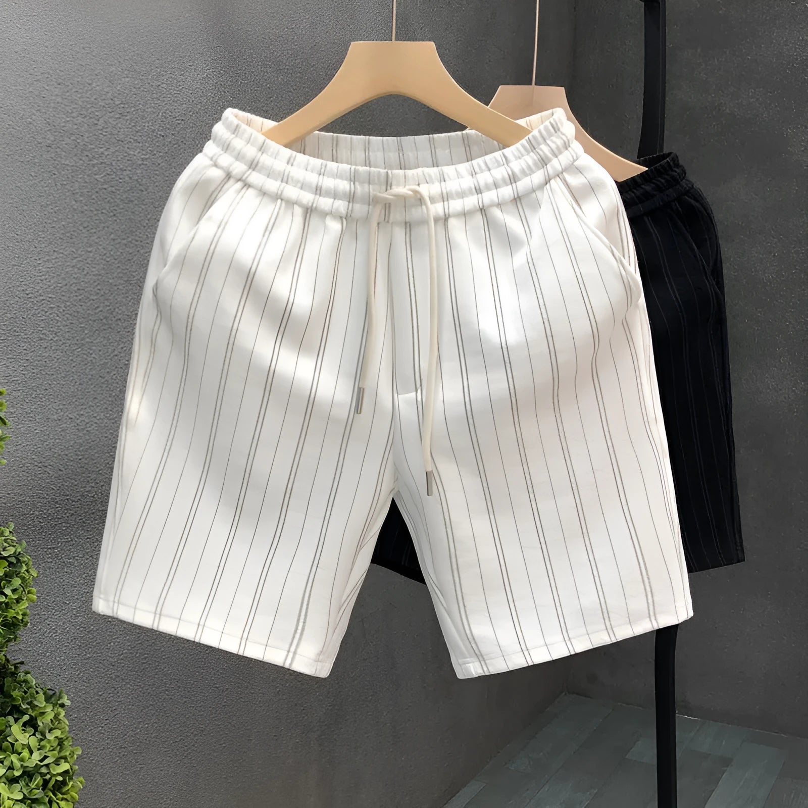 Men's black and white striped casual shorts with fleece lining and elastic waistband shown in straight cut design