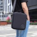 Switch console storage bag in black with shoulder strap, holding game cartridges.