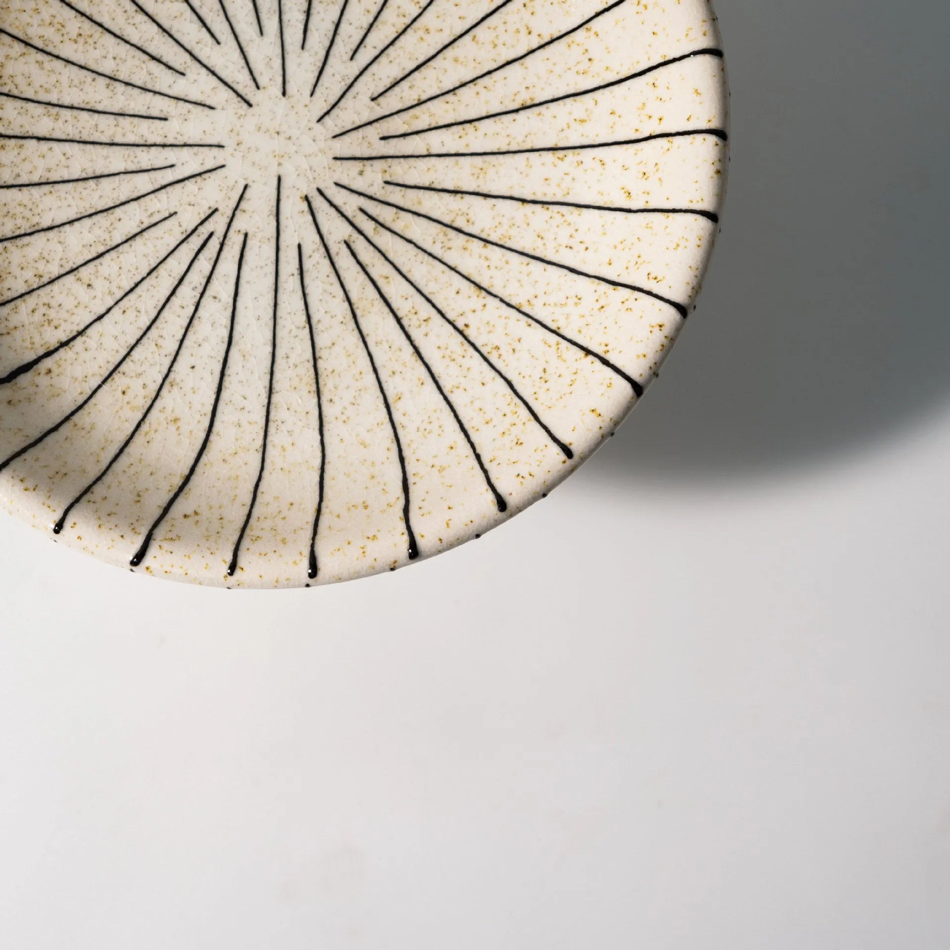 Black and white striped plastic resin fruit plate ornament, 16cm diameter, on a table.