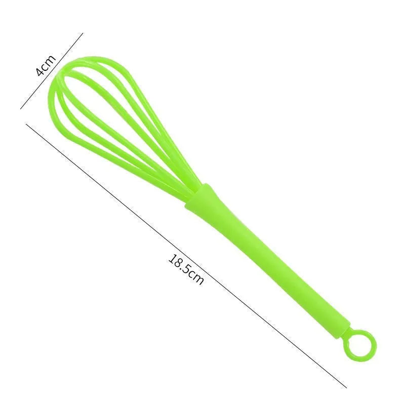 Plastic mini manual eggbeater in green for stirring batter in a kitchen