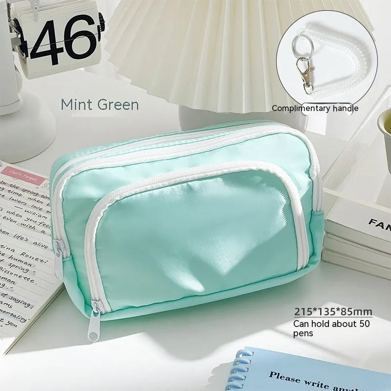 Double layer zippered pencil case in blue with an attached carry handle, showing two compartments.