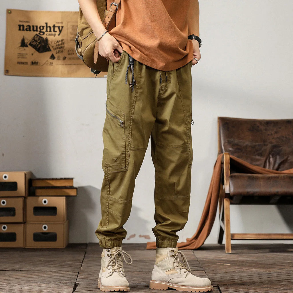 Men's khaki cotton tapered harem pants with a small ankle opening and mid-waist design on a neutral background.