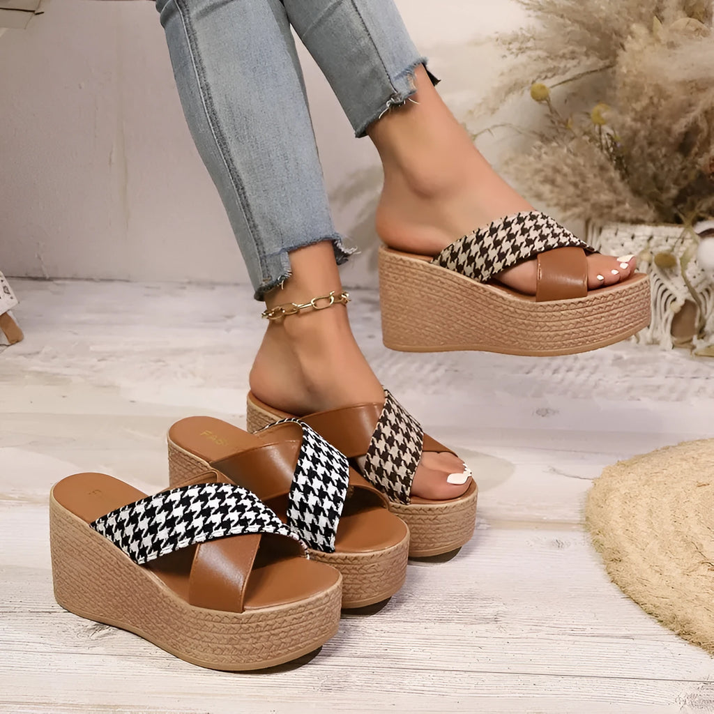 Leopard print plaid wedge sandals in brown and black with a rubber sole, shown in a casual setting.