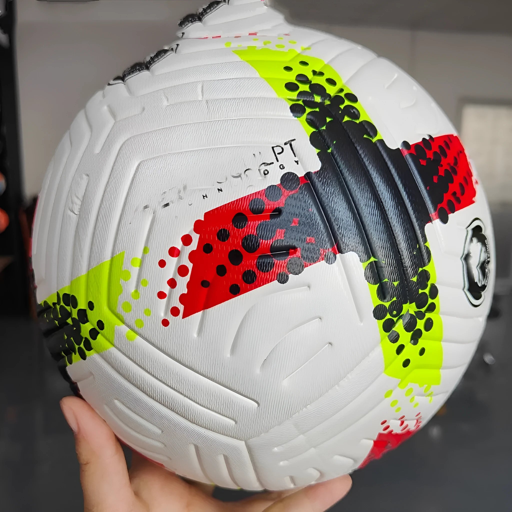 Fluorescent green official Size 5 football with seamless thermal adhesive patch PU construction on a training pitch.