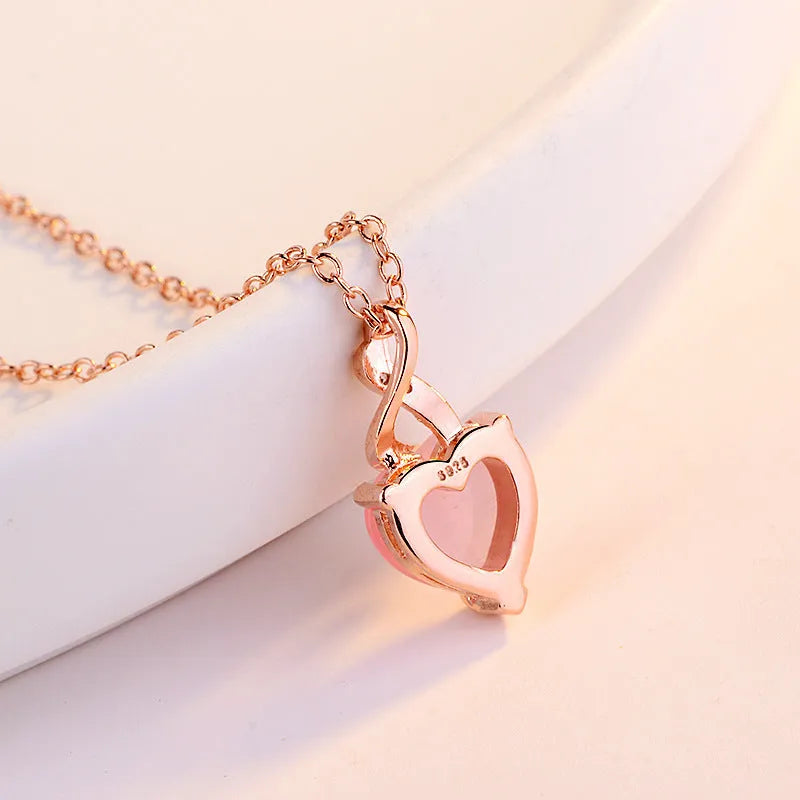 Rose gold women's necklace with heart-shaped pink crystal pendant on cross chain