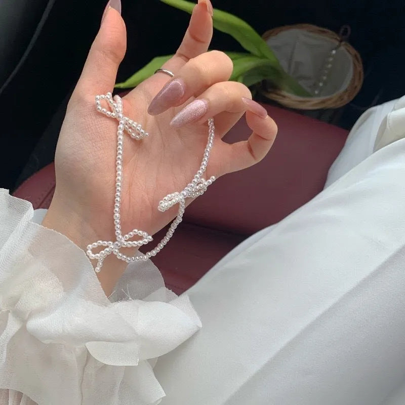 White geometric bow detail on an adjustable imitation pearl necklace for women, chain length 31-40cm.
