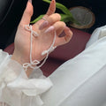 White geometric bow detail on an adjustable imitation pearl necklace for women, chain length 31-40cm.