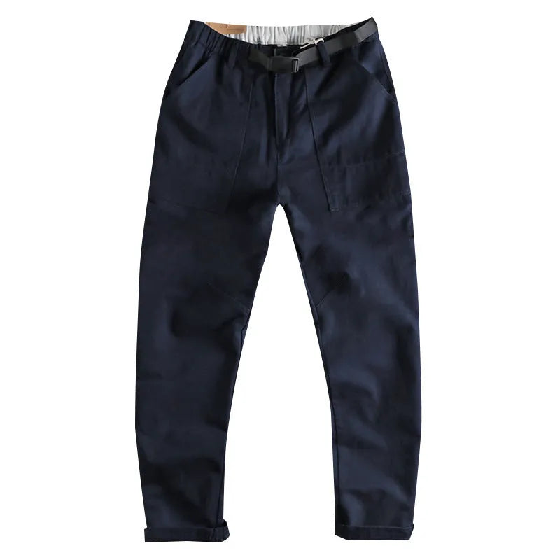 A pair of men's khaki cotton work trousers with a mid waist and zip fly on a plain background.