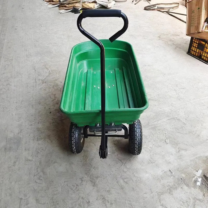 Green TC2145 four-wheel toy dump truck with steel frame and plastic body in a garden setting.