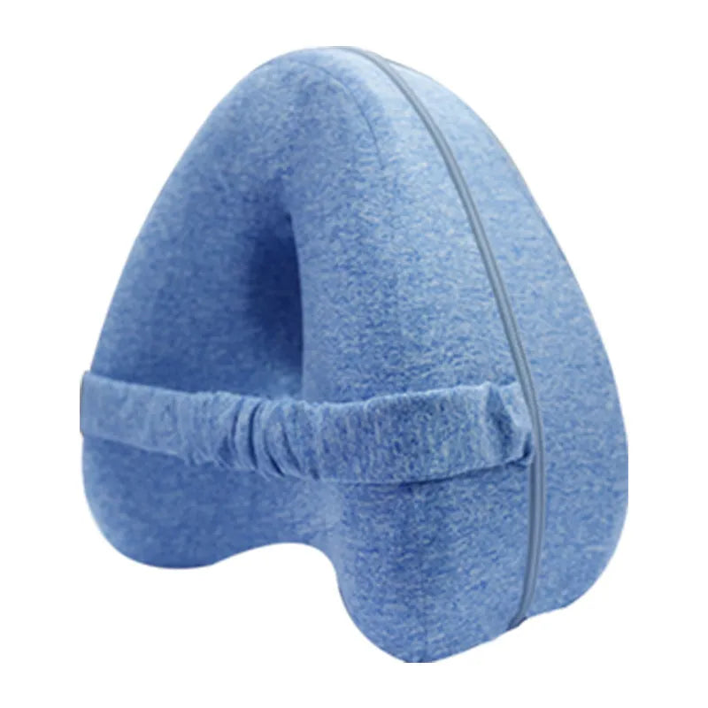 Heart-shaped dark blue jacquard memory foam leg pillow for adults on a bed.