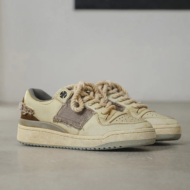 Beige vintage style low top skateboard shoes with flat rubber sole and lace-up front.