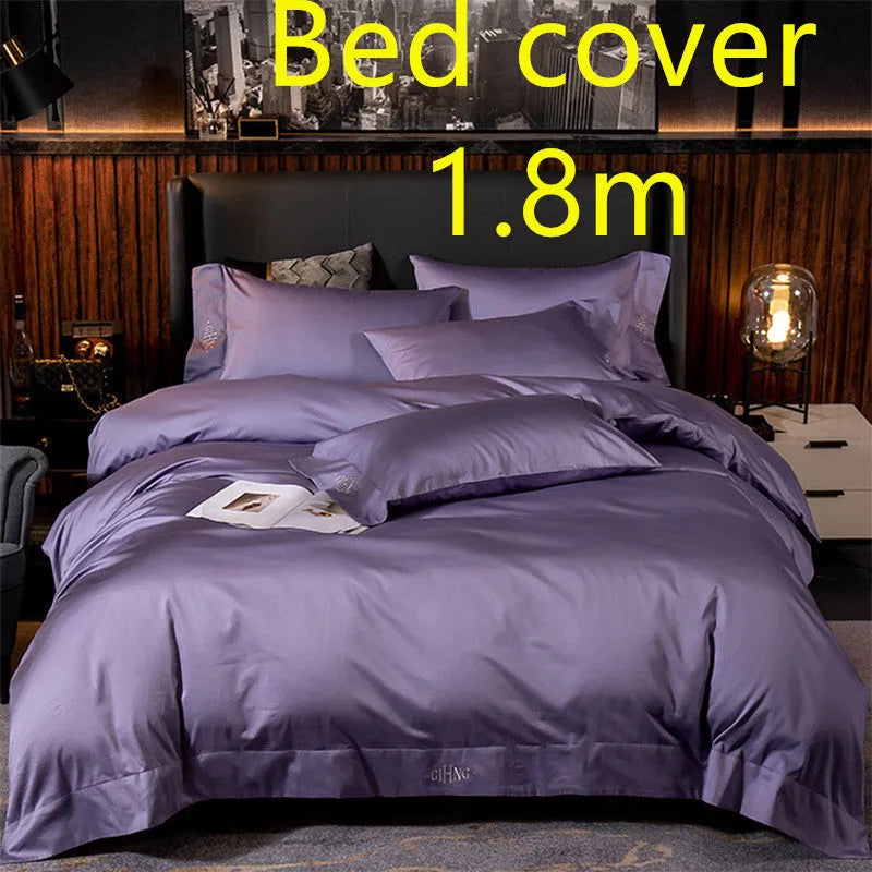 Four-piece cotton satin quilted bedding set with duvet cover, sheet, and pillowcases in a bedroom setting