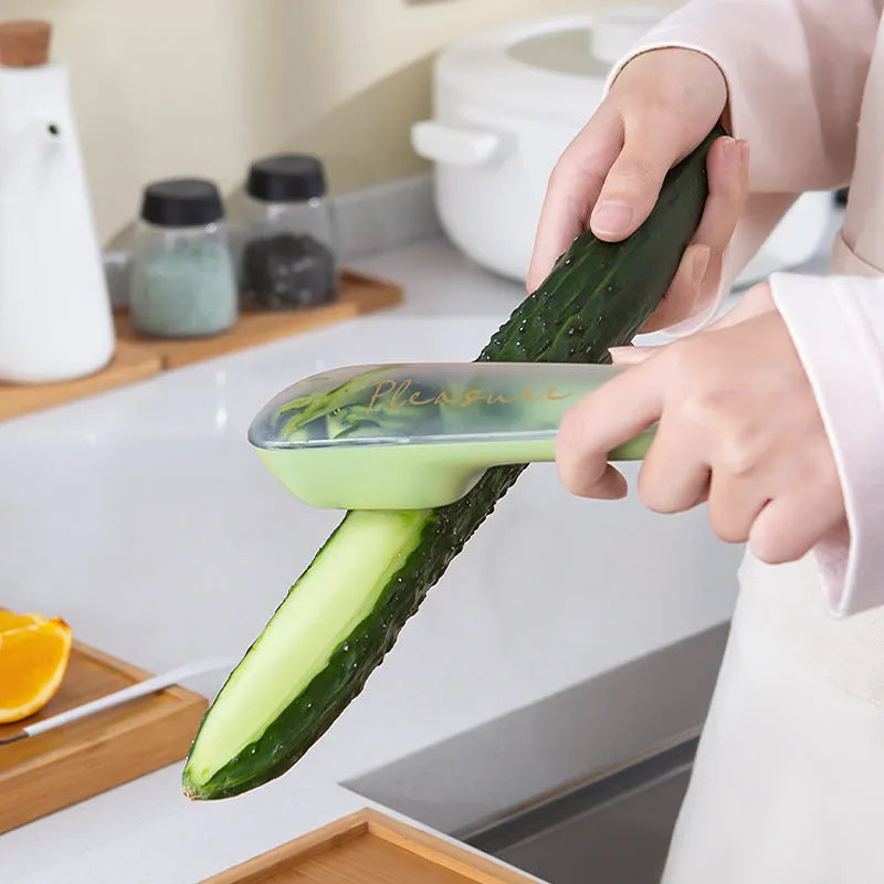 Dark green kitchen peeler with storage tube, showing stainless steel blade and non-slip handle.