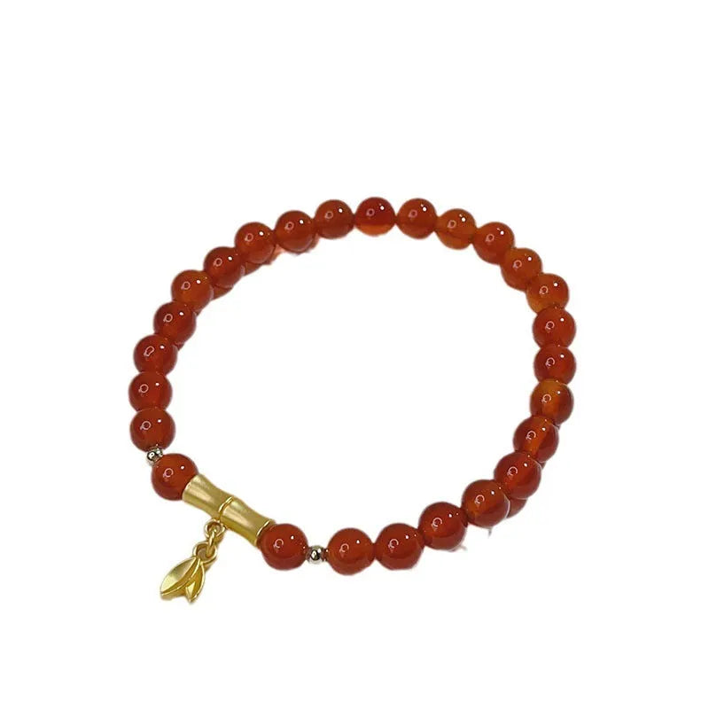Close-up of a red agate bracelet with a Chinese dragon design on a woman's wrist.