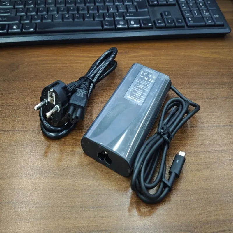 Black oval 65W Type-C laptop power adapter with multiple international plug configurations