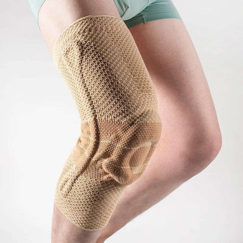 Adult sports knee pad in black and blue colour, shown on a knee for running and basketball protection.