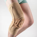 Adult sports knee pad in black and blue colour, shown on a knee for running and basketball protection.