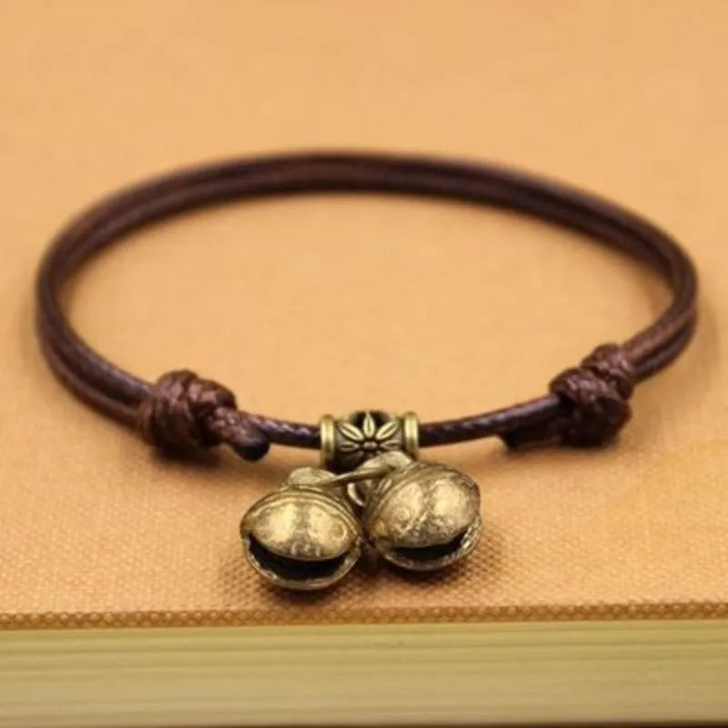 Adjustable nylon dog collar with a brass bell on a black rope, showing the fitting and casual style.