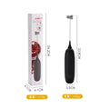 Black and white handheld electric milk frother and blender on a kitchen counter.