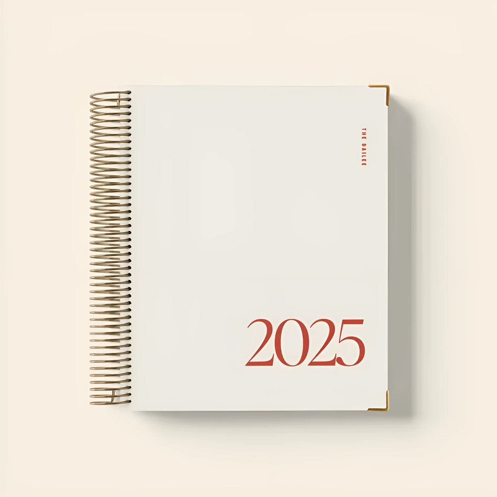 Cherry red A5 coil notebook open on a desk, showing spiral binding and lined paper