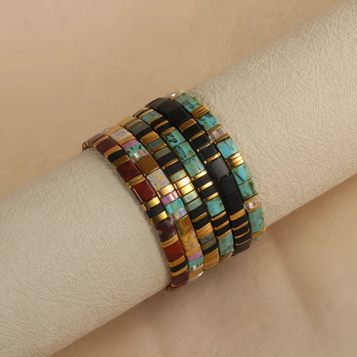 Adjustable geometric beaded bracelet with pull beads in milky white, black, green, blue or red.