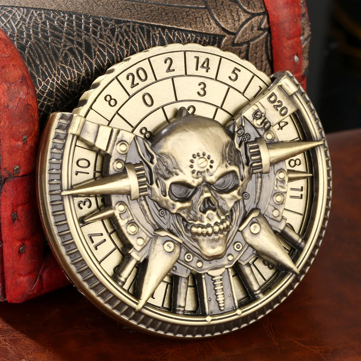Skeleton metal wheel dice gift box with bronze D20 and D10 dice on a dark tabletop