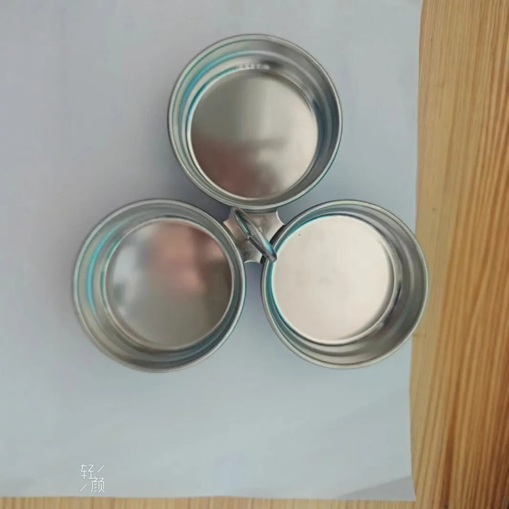 A small stainless steel egg steamer in a heart shape next to a round version, for cooking eggs on a hob.