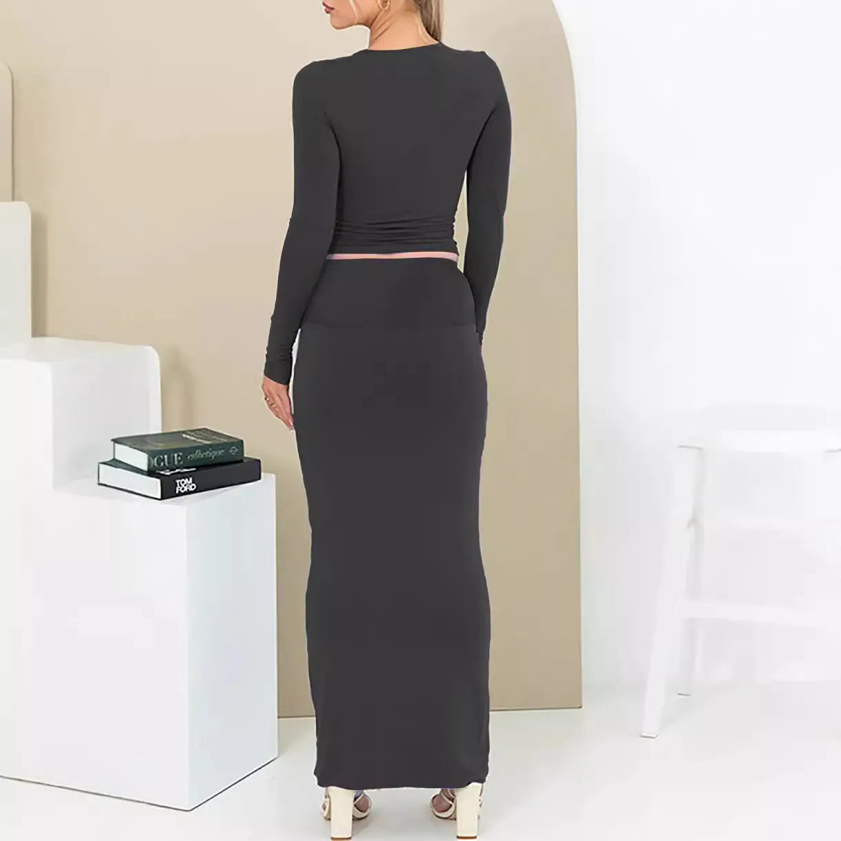 Women's black two-piece suit set with three-quarter sleeve top and long skirt on a mannequin.