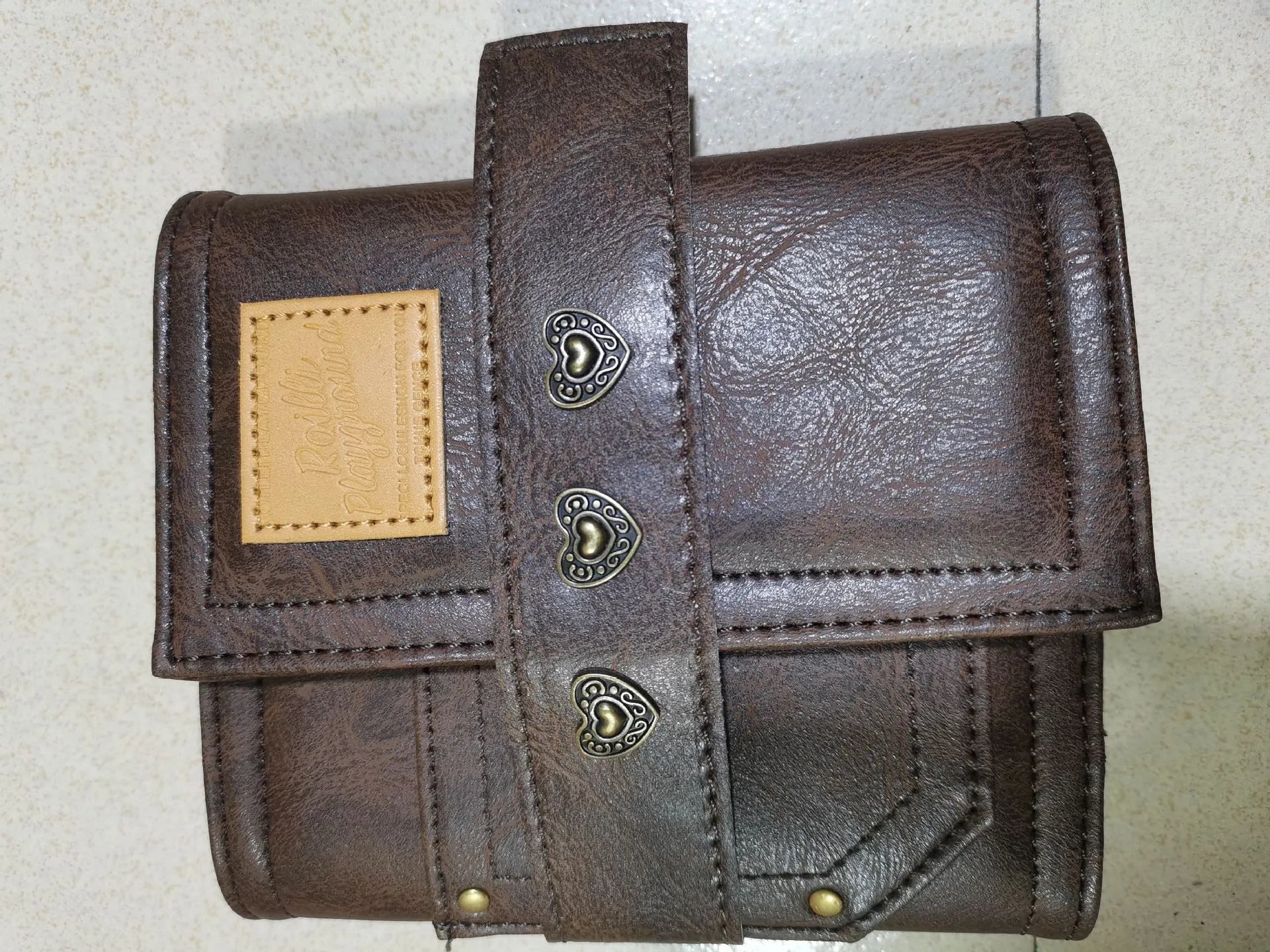 Brown A7 size notebook with a PU leather-look cover and metal buckle closure.