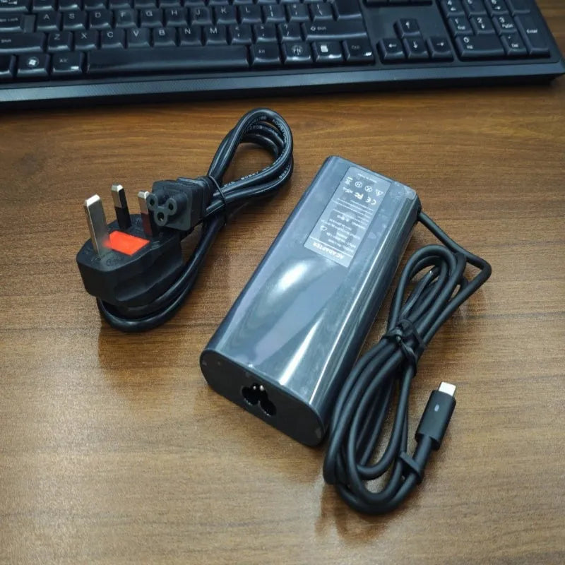 Black oval 65W Type-C laptop power adapter with multiple international plug configurations
