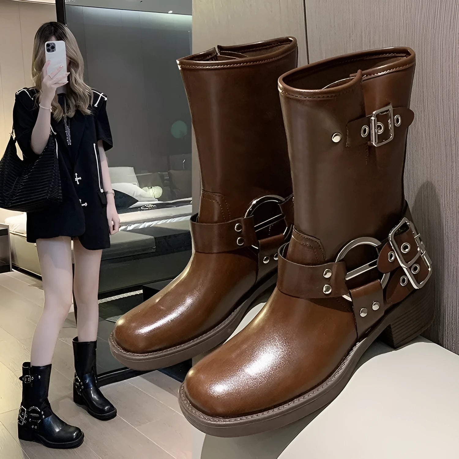 Women's black platform boots with belt buckle detail showing middle calf length