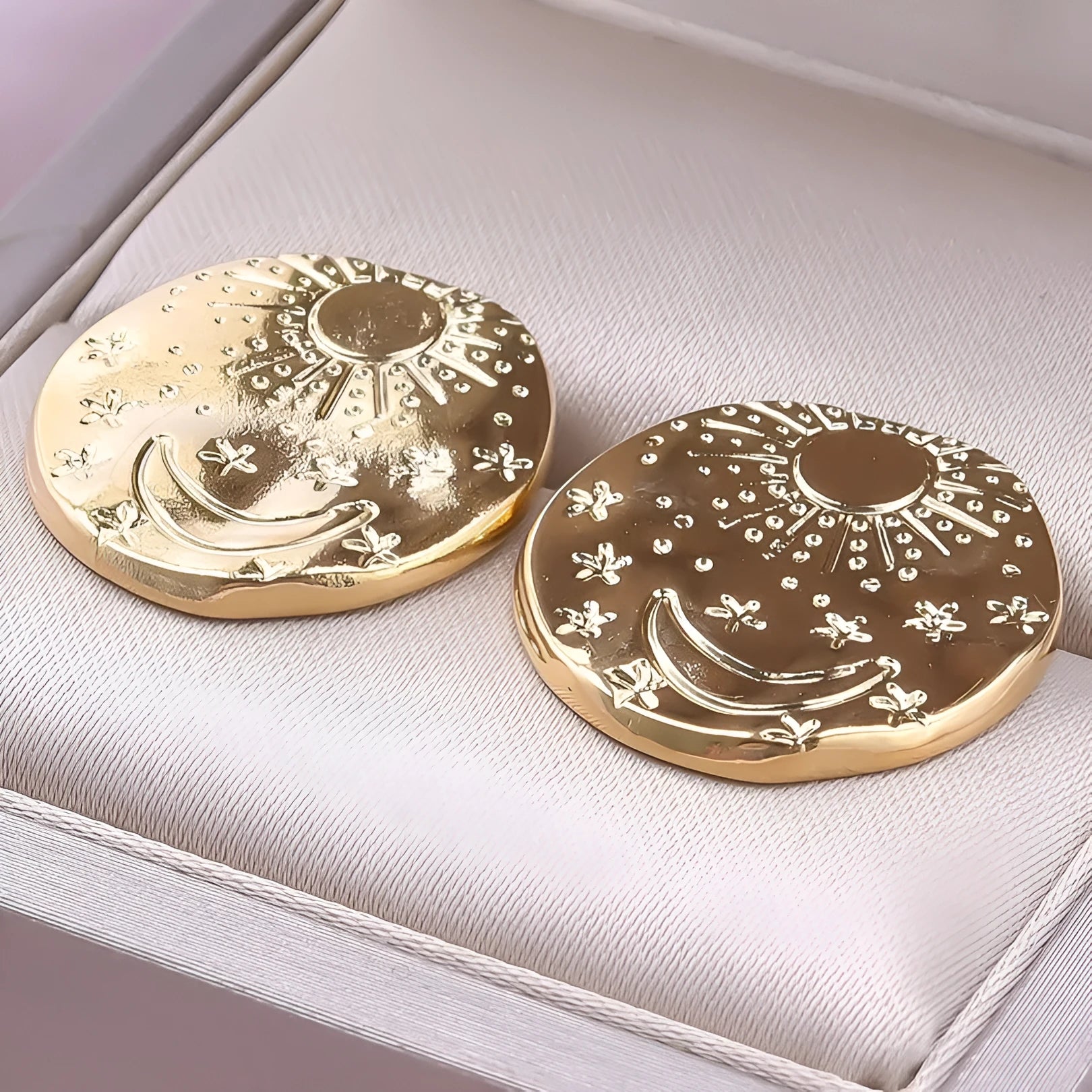 A pair of geometric shell design stud earrings in stainless steel with a gold electroplated finish.