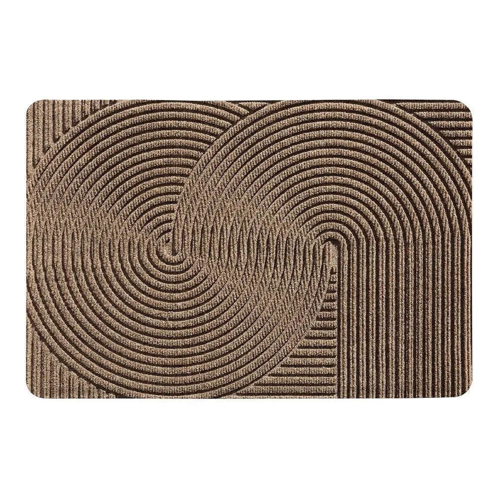 Green alien-shaped entrance mat with cartoon pattern on a wooden floor.