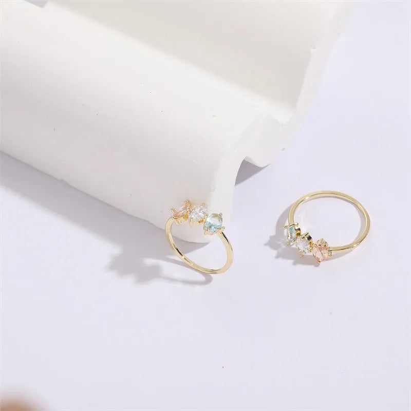 Geometric triangle copper ring with horse eye motif, tricolor zircon, and gold electroplate finish.