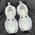 Beige mesh platform sports shoes with a wedge heel and lace-up front.