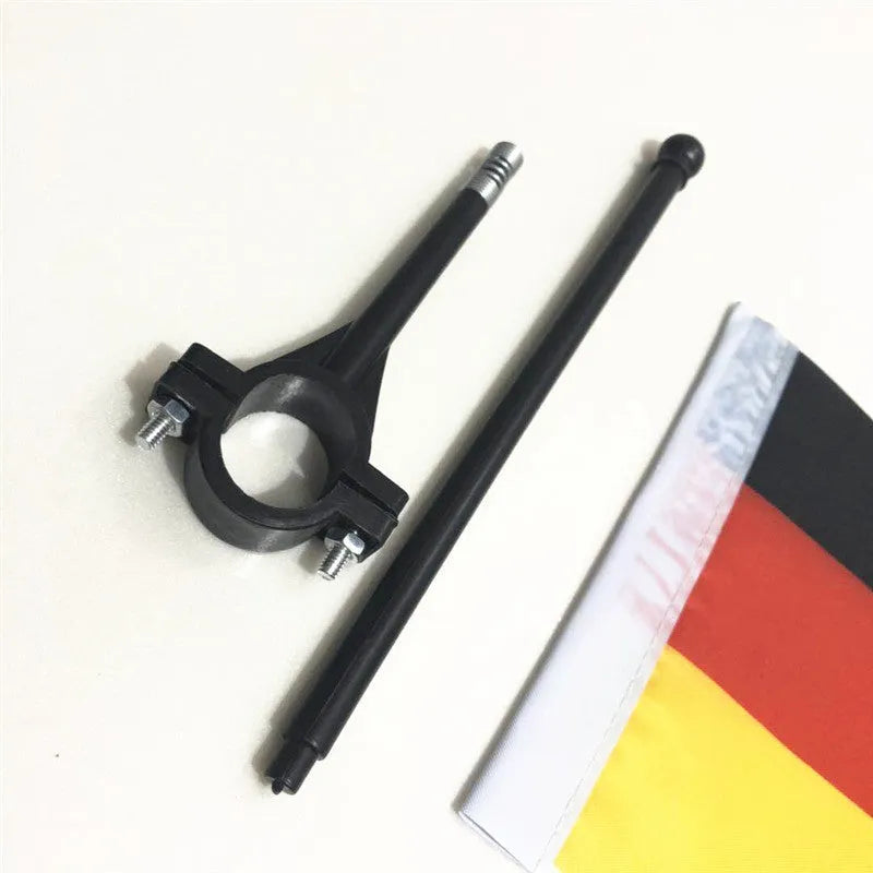 A plastic handlebar flagpole with a square polyester fabric flag attached, mounted on a bicycle.