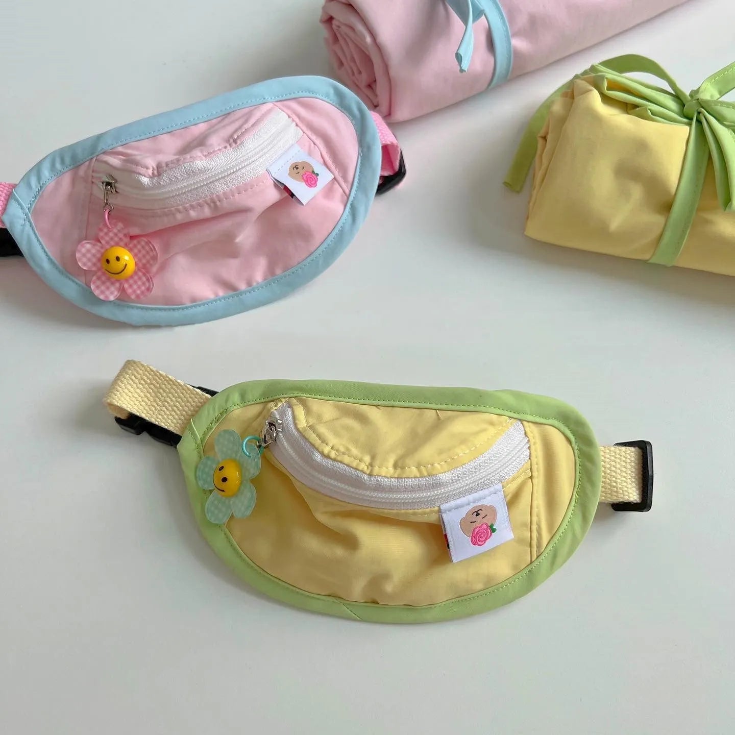 Pink adjustable backpack-style messenger bag carrier for a small dog or cat, showing the poop bag holder.