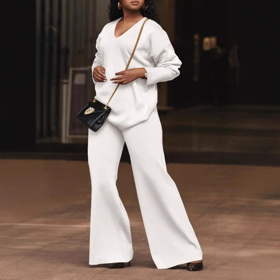 Brown women's suede two-piece suit with split sleeves and matching trousers on a hanger.