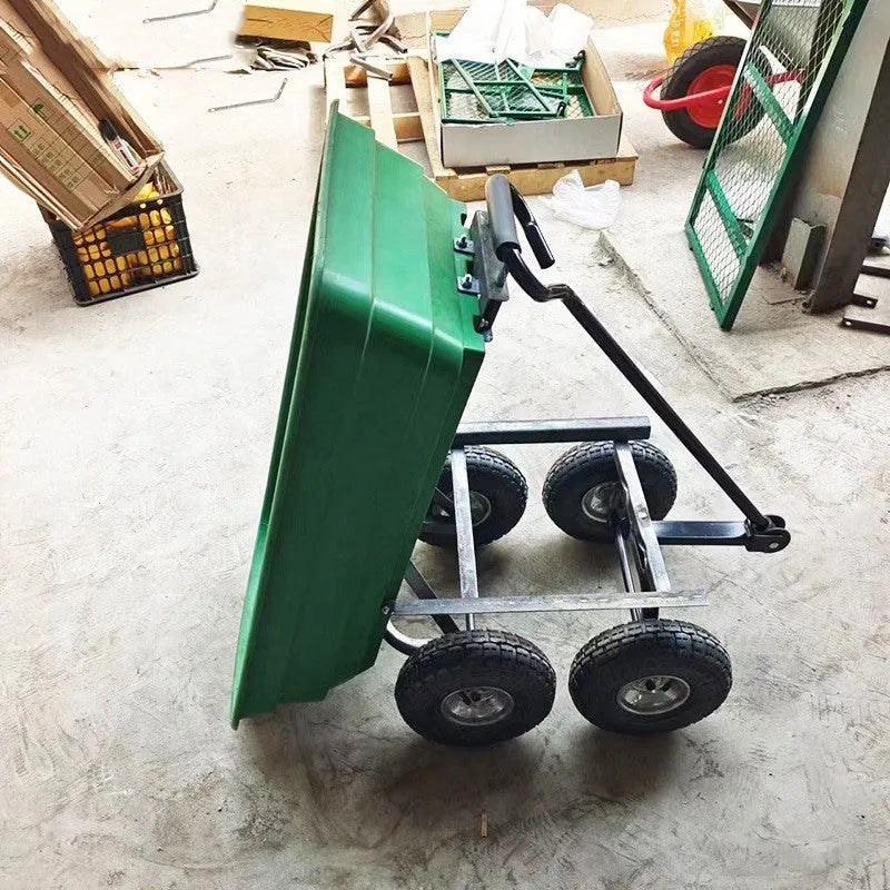 Green TC2145 four-wheel toy dump truck with steel frame and plastic body in a garden setting.