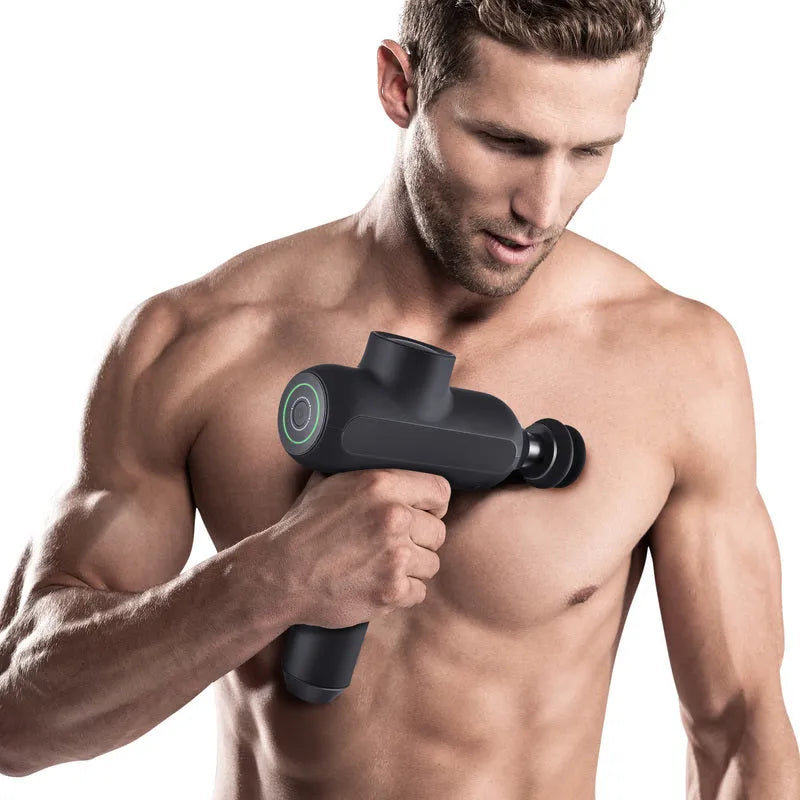 Handheld black muscle massager with six different coloured massage heads on a table.