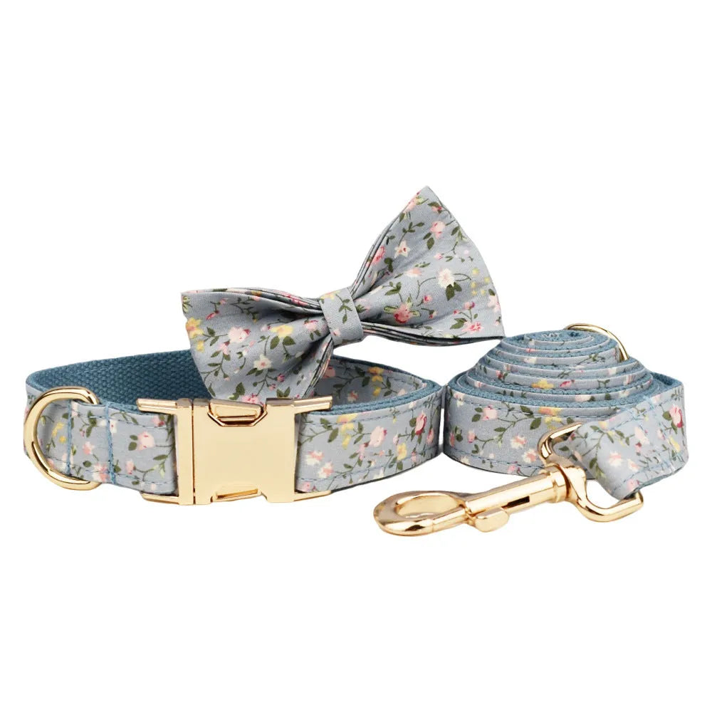 Blue floral pattern dog collar with matching leash, bow tie, vest and waste bag accessories on white background