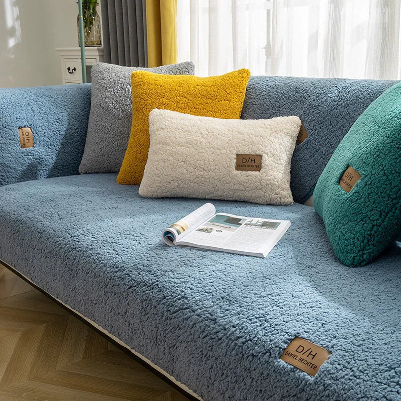 Beige plush lamb wool sofa cover with anti-slip backing laid flat on a modern grey sofa.
