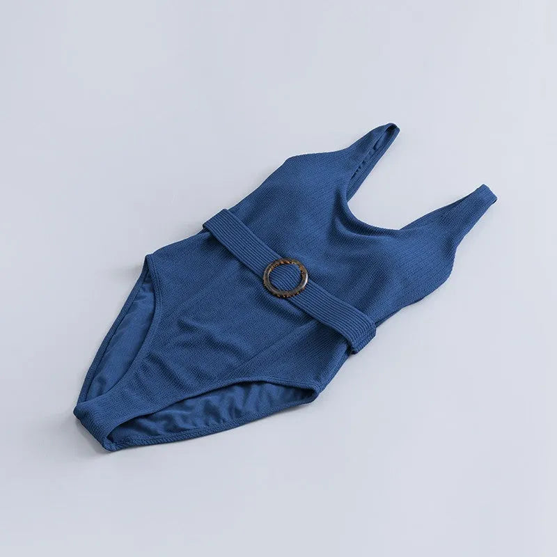 Navy blue women's one-piece triangle swimsuit with chest pads on a mannequin, showing the sleeveless slimming design.