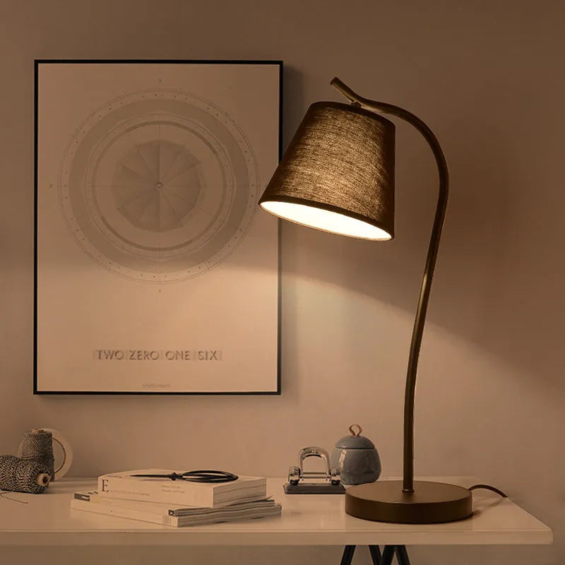 A modern LED table lamp with a push button dimmer switch on its base.