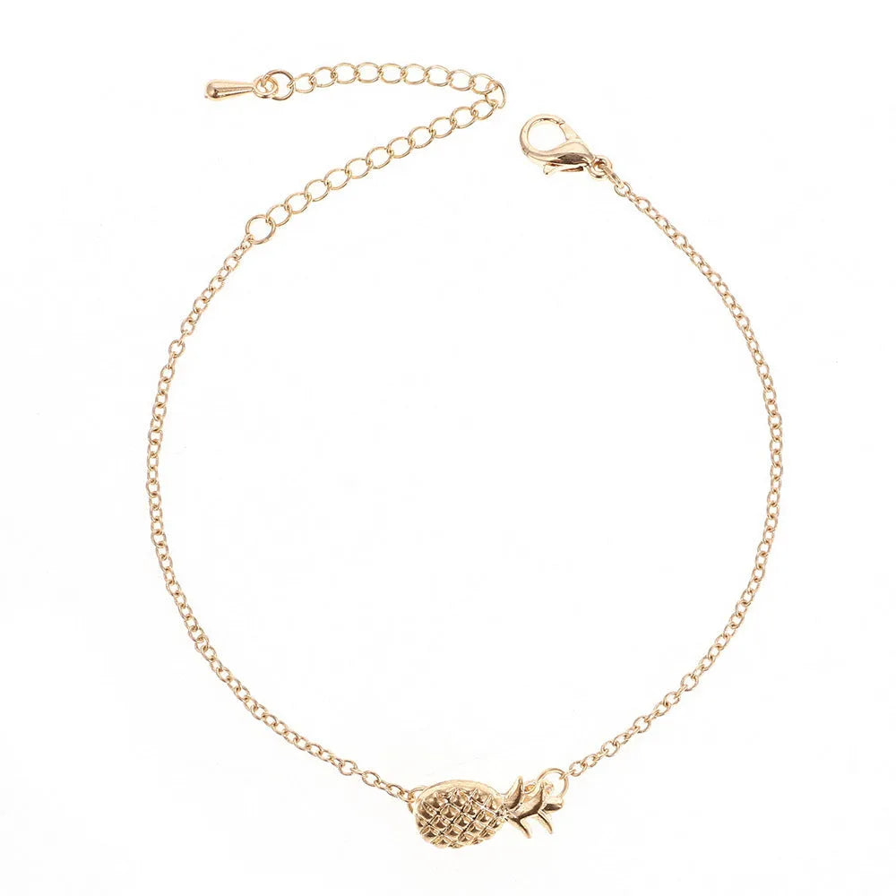 Close-up of a gold-colour alloy bracelet shaped like a pineapple on a wrist.