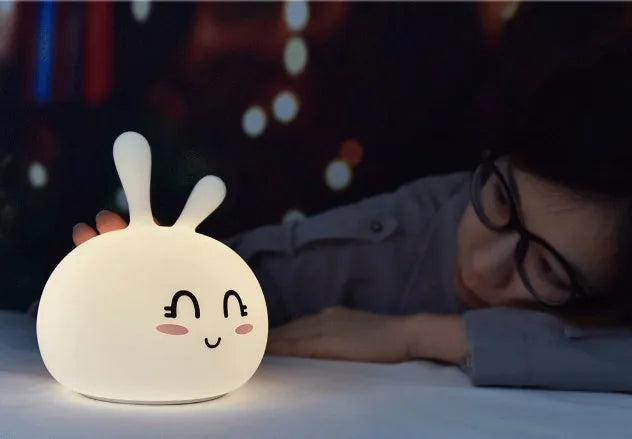 Marshmallow Bunny LED Night Light with 0.4W ABS silicone construction and happy face expression on a bedside table
