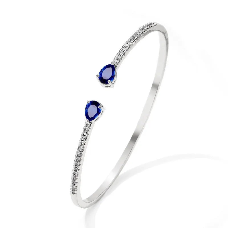 Adjustable copper bracelet with inlaid white zircon stones on a wrist.