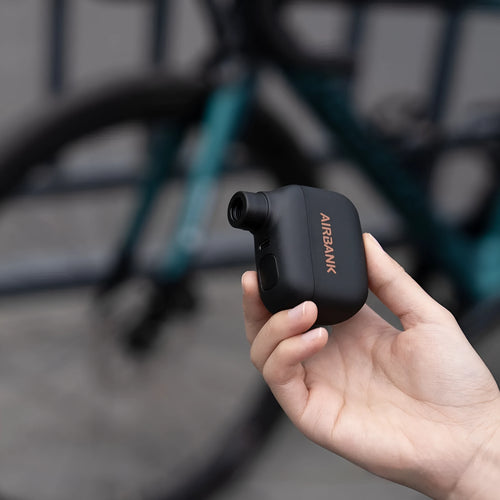 Black AS100 mini electric bike pump with USB charging cable and waterproof bag.