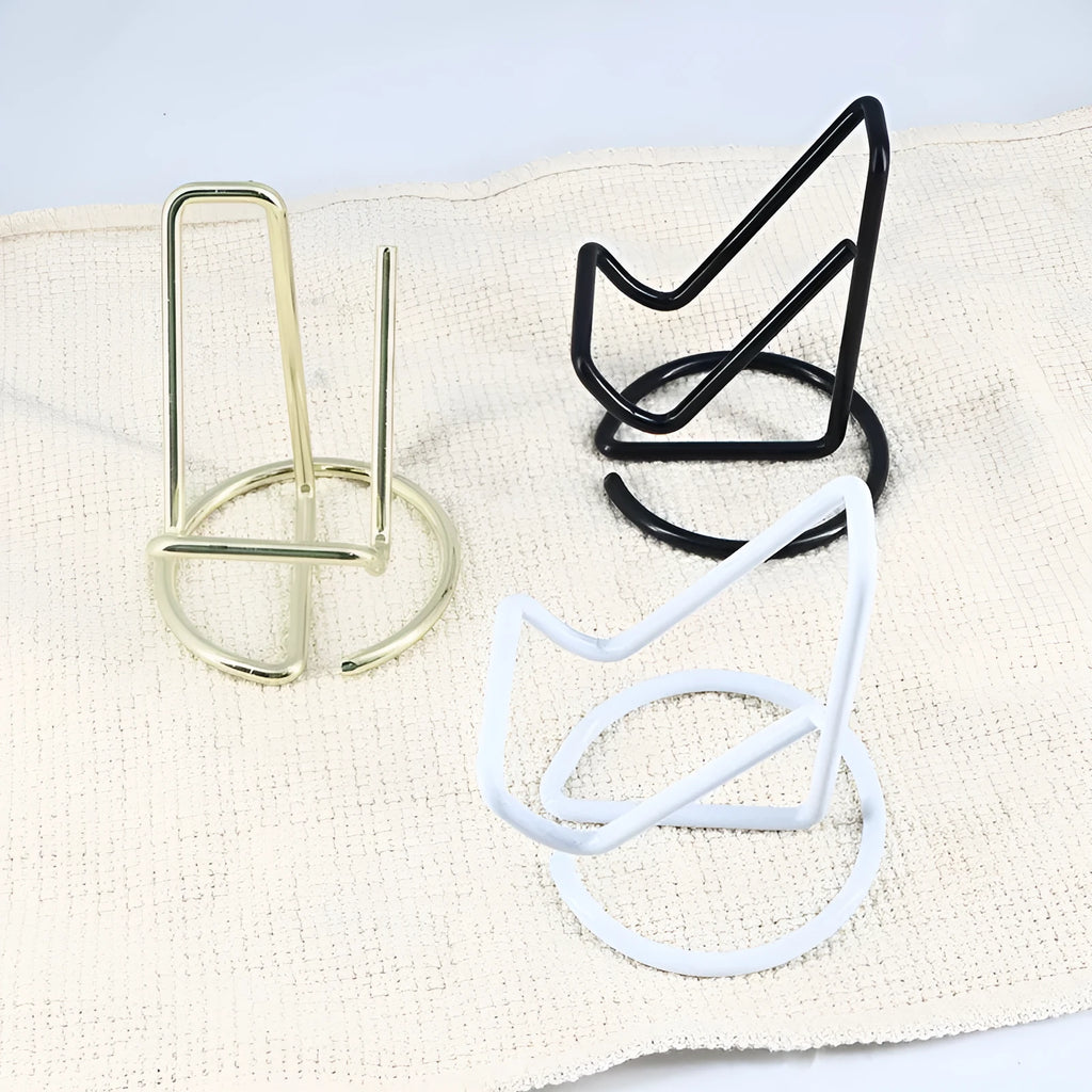 Wrought iron desktop mobile phone bracket in black chair support design on a wooden desk